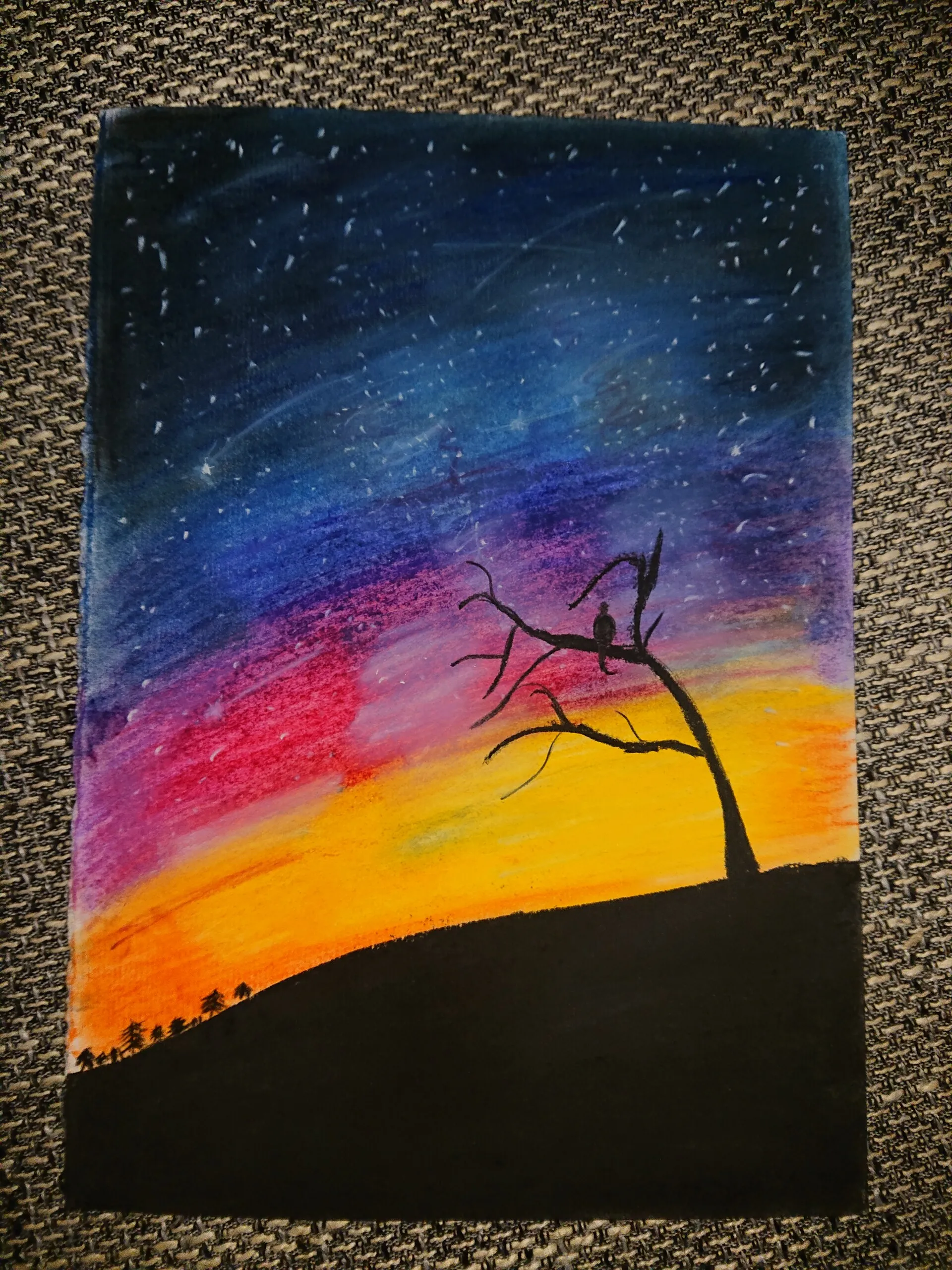 Sternenhimmel über glühendem Horizont, davor ein kahler Baum als Silhouette